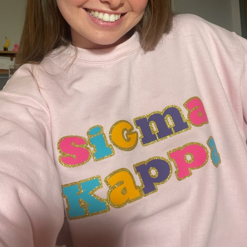 Sigma Kappa light pink sweatshirt with gold glitter and colorful letters